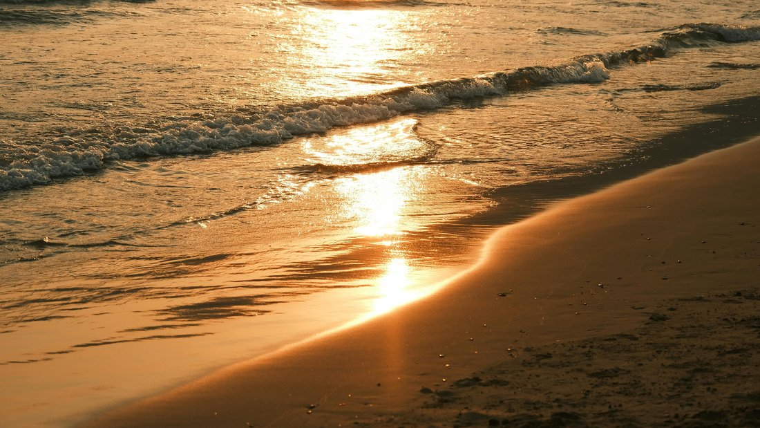 Golden hour waves breaking on the shore