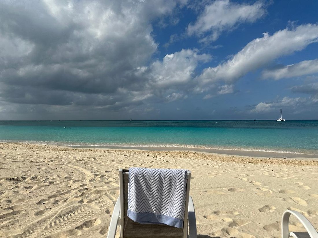 Beach chair and towel overlooking calm turquoise water at a Maison Solvere beach